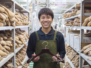 倉庫でハンガーを持つ職人の写真