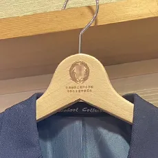 ブレザーがかけられた、オリジナルのロゴ入りハンガーの写真