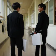 校舎の廊下で話している男子生徒2人の写真