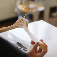 オリジナルのロゴが入った木製ハンガーと白いギフトボックスの写真